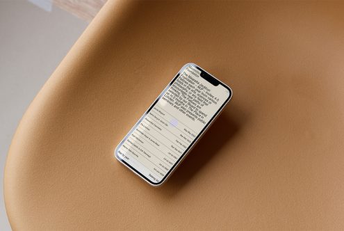 Smartphone mockup on brown leather background displaying text interface, ideal for presenting app designs and user interfaces to clients.